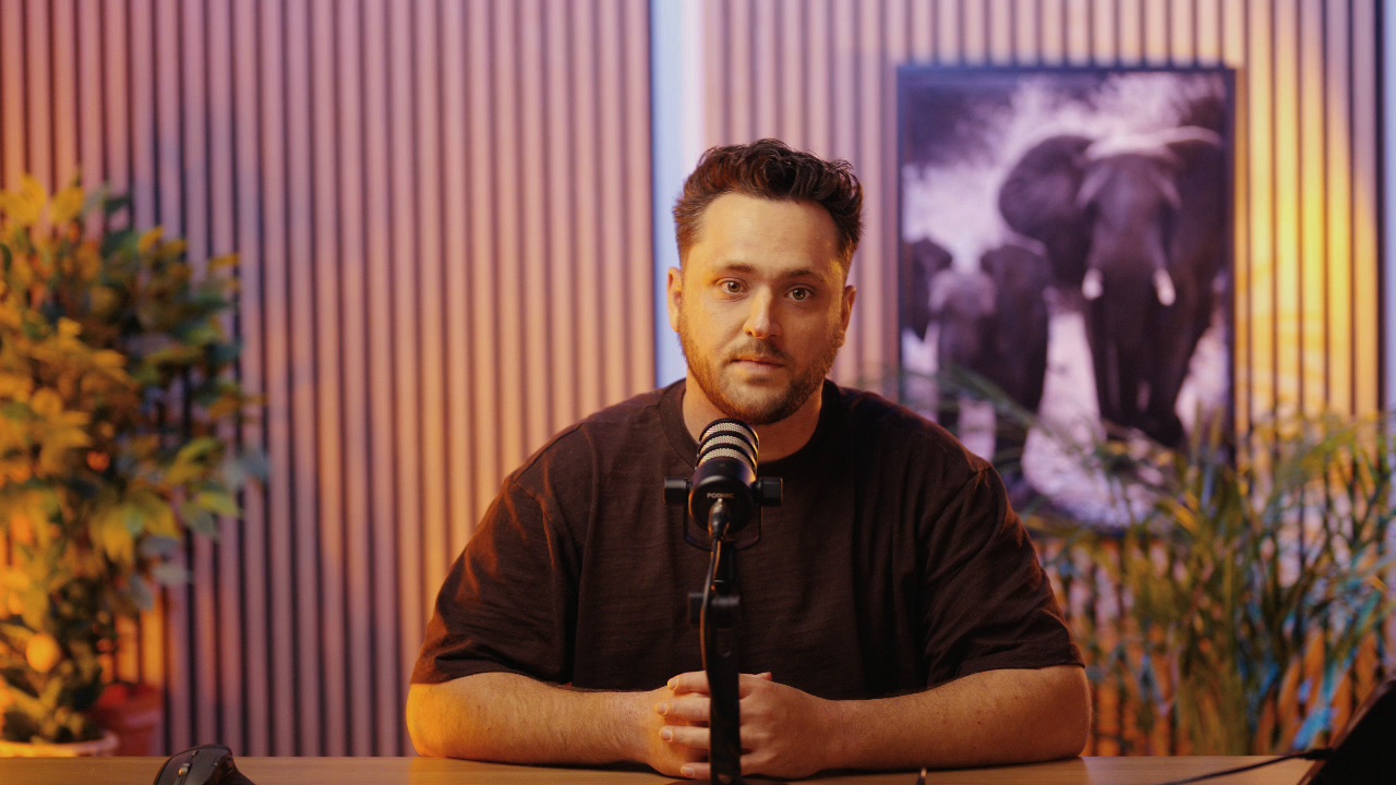 Stan Vreuls aan tafel achter een microfoon in de studio