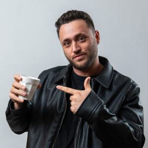 SEO specialist Maastricht Stan Vreuls staat uitnodigend met een kopje koffie in zijn hand. Deze foto wordt gebruikt voor verzoek om afspraken te maken en sluit goed aan bij de brnading en huisstijl van een marketingbureau in Maastricht